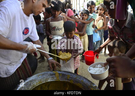 Rohingya i bambini rifugiati raccoglie il cibo al palongkhali campo di fortuna in Cox bazar, Bangladesh, su ottobre 06, 2017. Secondo il regno nat Foto Stock