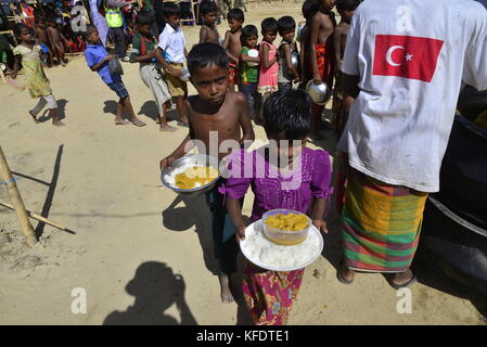 Rohingya i bambini rifugiati raccoglie il cibo al palongkhali campo di fortuna in Cox bazar, Bangladesh, su ottobre 06, 2017. Secondo il regno nat Foto Stock