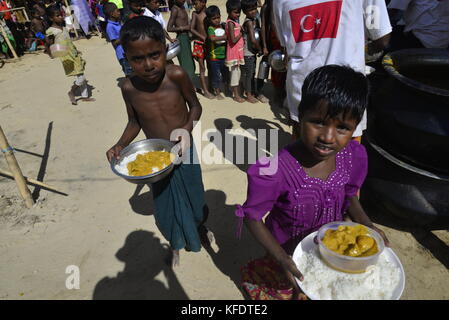 Rohingya i bambini rifugiati raccoglie il cibo al palongkhali campo di fortuna in Cox bazar, Bangladesh, su ottobre 06, 2017. Secondo il regno nat Foto Stock