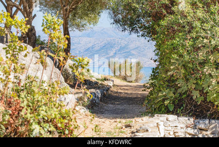 Grecia costa calma, acque blu, rocce, paesaggi mediterranei, mar Ionio, vista da Kassiopi, in background - costa albanese e le montagne. Foto Stock