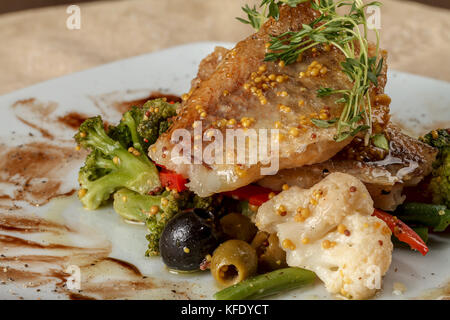Bianco fritto i filetti di pesce con i cavolfiori e cavoli broccoli, con pepe e olive e fagioli Foto Stock