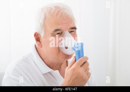 Close-up di un anziano uomo inalazione attraverso le maschere di ossigeno in clinica Foto Stock