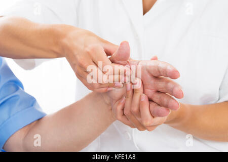 Close-up di una persona che riceve il massaggio di Palm dal fisioterapista Foto Stock