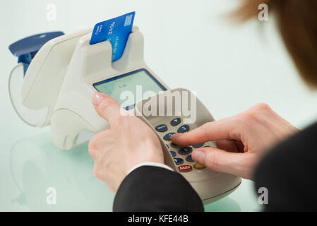 Close-up di donna mano utilizzando la macchina per le carte di credito Foto Stock