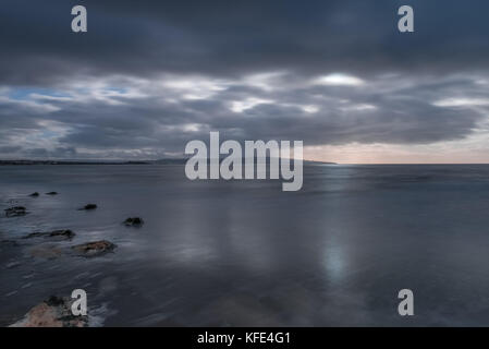 Da prestwick bay oltre a Ayr, capi di Ayr e al di là dei cieli sono drammatiche e gli ultimi raggi di sole è fuoriuscita attraverso la pesante dark cloud im Foto Stock