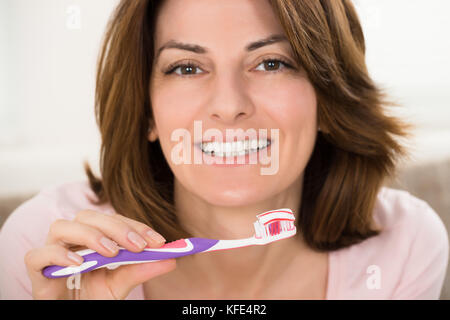 Close-up di una donna sorridente con spazzolino e dentifricio Foto Stock