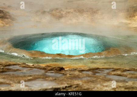 Azzurro acqua che sgorga dalla terra in un potente geyser Foto Stock