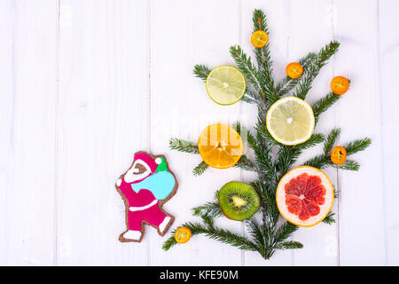 In casa di panpepato cookie smaltati e albero di natale rami con frutti. Foto Stock