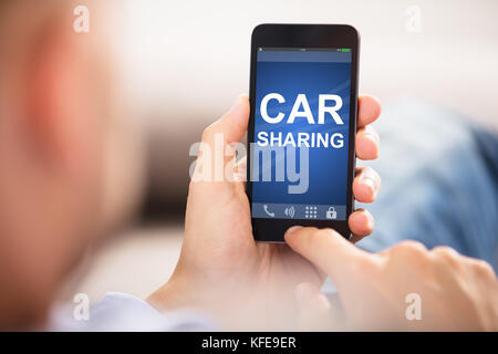 Close-up di un uomo con il Car Sharing Applicazione su Smart Phone Foto Stock