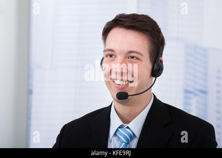 Ritratto di certi giovani proprietari che indossa la cuffia in office Foto Stock