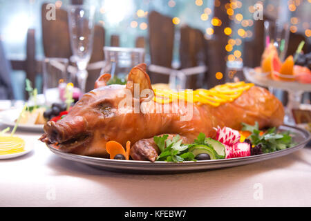 Arrosto di maiale. porchetta con le verdure sul piatto da portata Foto Stock