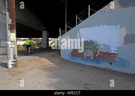 Uomo in bicicletta passato muro rana murale dipinto su Glendale Ponte Freeway a Frogtown in Elysian Valley NE Los Angeles CALIFORNIA USA KATHY DEWITT Foto Stock