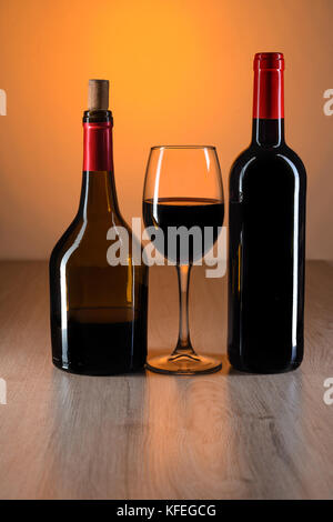 Bottiglia di vino rosso sul tavolo di legno con belle riflessioni Foto Stock