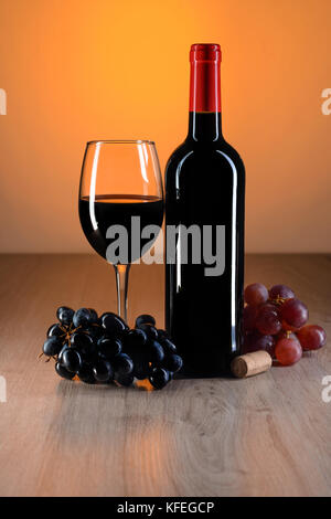 Bottiglia di vino rosso sul tavolo di legno con belle riflessioni Foto Stock