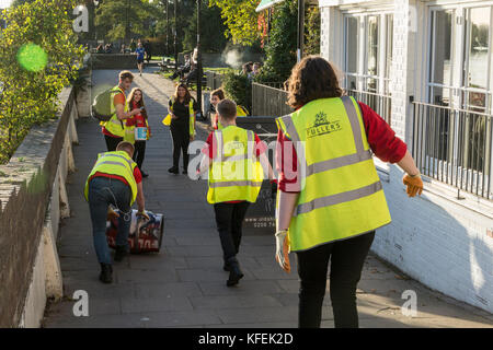 Gli studenti che partecipano a un barile-rolling fundraising evento di beneficenza per Fuller's Griffin birreria a Chiswick, Londra, Regno Unito. Foto Stock