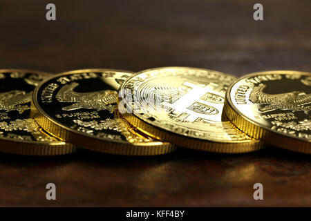 Bitcoin in una fila di 1 oncia di oro americano eagle bullion monete Foto Stock