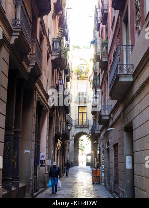 Barcellona, Spagna - 11 Nov 2016: Le persone sono a piedi verso il basso di uno stretto vicolo in storico di Barcellona Bari Gotic Quarter. Foto Stock