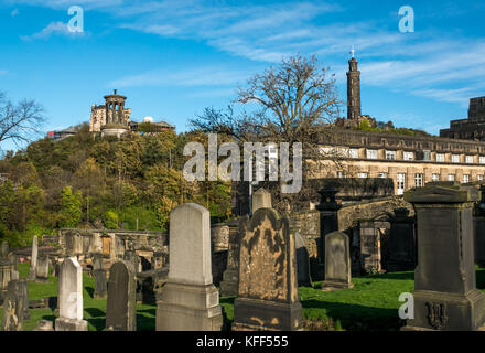 Vecchie lapidi in Old Calton seppellimento cimitero di massa Edimburgo in Scozia e la vista da Calton Hill, con colonna di Nelson e Dugald Stewart monumento Foto Stock