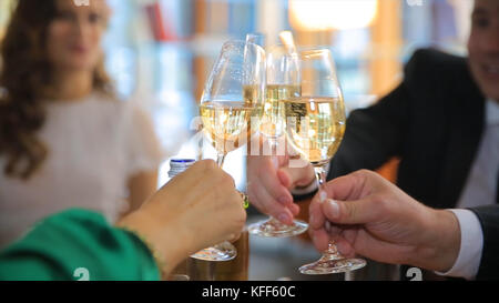 Mani che tengono i bicchieri e brinda, la gente fa il tifo con un bicchiere di champagne. felice momento festivo, concetto di festa di lusso. Bicchieri di champagne in mano Foto Stock