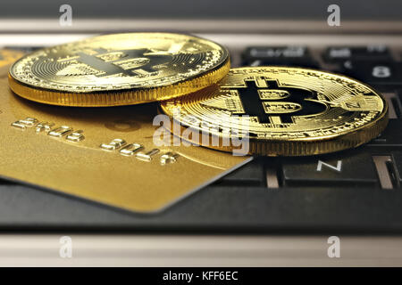 Bitcoins e carta di credito su una tastiera portatile Foto Stock