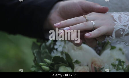 Anello antiusura della sposa sul dito dello sposo. Lo sposo mette l'anello nuziale al dito della sposa. mani di matrimonio con anelli. birde indossa l'anello sul dito dello sposo Foto Stock