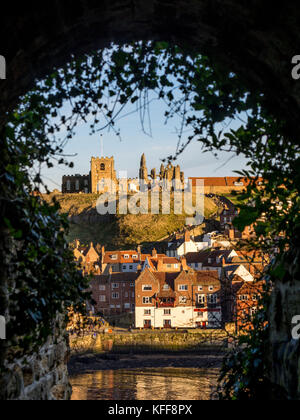 Whitby Abbey e St Mary's Church a East Cliff, incorniciate attraverso il Screaming Tunnel, noto anche come Dracula's Tunnel. REGNO UNITO Foto Stock