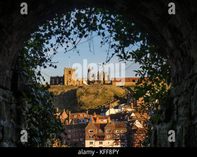 Whitby Abbey e St Mary's Church a East Cliff, incorniciate attraverso il Screaming Tunnel, noto anche come Dracula's Tunnel. REGNO UNITO Foto Stock