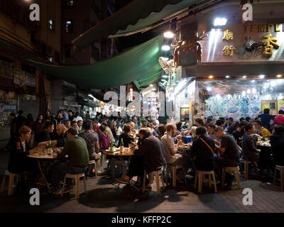 Ristorante mostrare alla gente che si diverte e mangiare al-gether in Temple Street, il Mercato Notturno, Kowloon, Hong Kong, Cina, Asia. Foto Stock