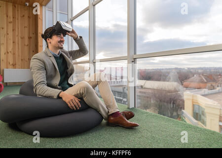 Business man indossare occhiali digitale la realtà virtuale si siedono di fronte finestra panoramica imprenditore centro coworking Foto Stock