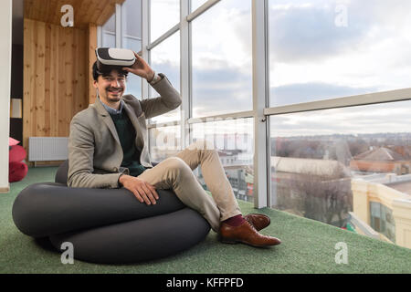 Business man indossare occhiali digitale la realtà virtuale si siedono di fronte finestra panoramica imprenditore centro coworking Foto Stock