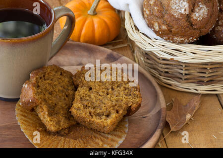 Tagliate a fette muffin di zucca e la tazza di caffè su una piastra woodem Foto Stock