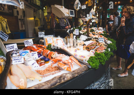 Vari tipi di pesci e crostacei sul display nella parte anteriore di un pescivendolo shop, Borough Market, Londra. Foto Stock