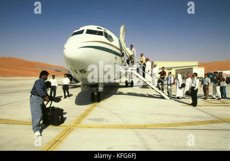 Saudi Aramco dipendenti pensione la Saudi Aramco 737 società piano a Shaybah aeroporto, dopo aver completato il loro lavoro duty tour presso il Gas Shaybah olio impianto di separazione (GOSP), una grande produzione di gas e petrolio stabilimento situato nel quartiere vuoto deserto di Arabia Saudita, vicino al confine degli EMIRATI ARABI UNITI. Foto Stock