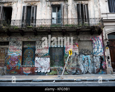 Vecchio edificio con balcone aperto windows e intavolato inferiore di windows coperto di variopinte graffiti in San Telmo quartiere di Bueno Aires. Foto Stock