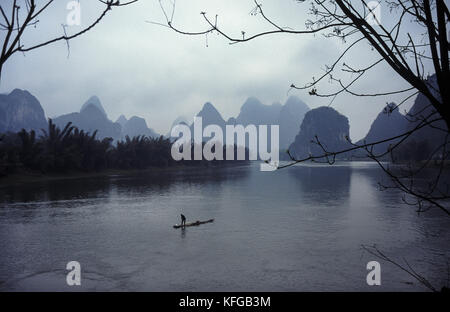 11.04.1995, Yangshuo, Guangxi, Cina, Asia - un pescatore tradizionale è visto alla deriva sul suo in zattera sul Fiume Lijiang in Yangshuo. Foto Stock