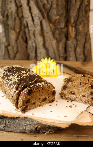 Pagnotta e fette di pane azzimo di segale senza lievito con uvetta spruzzata di semi di lino e di sesamo Foto Stock