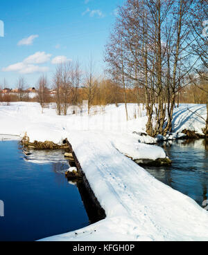 Paesaggio invernale con ponte di flusso su sfondo blu cielo Foto Stock