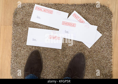 Close-up di persona i piedi e importanti lettere sullo zerbino Foto Stock