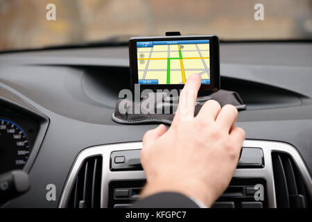 Primo piano dell'uomo che utilizza il sistema di navigazione GPS in auto Foto Stock