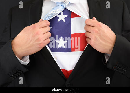 Primo piano di Un uomo d'affari che tira la sua camicia mostrando American Flag Foto Stock