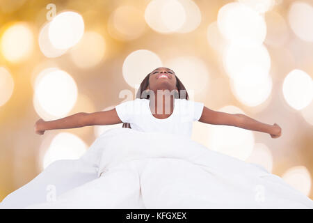 Felice giovane donna africana che si allunga a letto Foto Stock