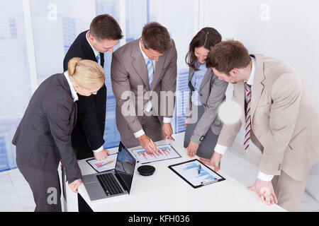 Un gruppo di giovani uomini di affari che lavora al tavolo da conferenza Foto Stock