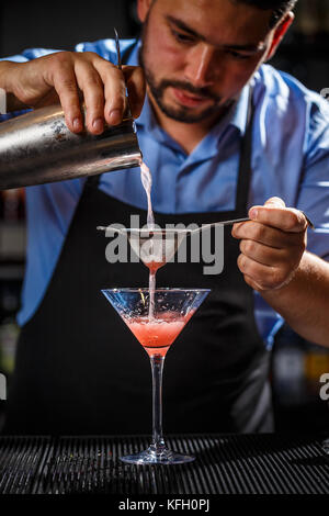 Esperto barman è rendere cocktail al night club. Foto Stock