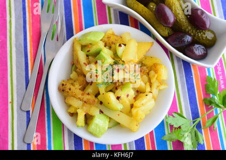 Teglia patate fritte con le zucchine in olio d'oliva, servita con verdure sottaceto. cucina casalinga. Il mangiare sano concetto Foto Stock