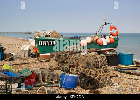 La pesca in barca tirata sulla spiaggia di ciottoli con pentole di aragosta Foto Stock