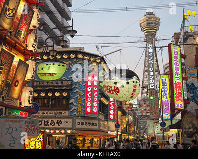 Un basso angolo di vista guardando verso l'alto la torre Tsutenkaku nel quartiere Shinsekai di Osaka in Giappone Foto Stock