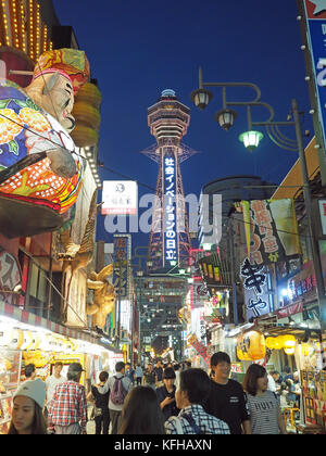 Un basso angolo di vista guardando verso l'alto la torre Tsutenkaku nel quartiere Shinsekai di Osaka in Giappone Foto Stock