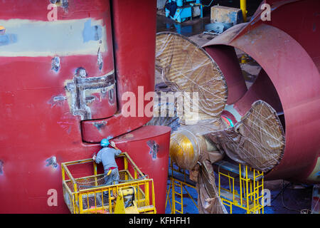 Un tecnico che aspetta il timone della nave in costruzione nel cantiere navale Foto Stock