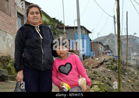 Lima, Perù. 12 settembre 2017. FILE - immagine del file che mostra Lucy Rivera (L) con sua figlia Sajuri vicino al muro nella baraccopoli di Pamplona nella capitale peruviana Lima, Perù, 12 settembre 2017. La baraccopoli è stata murata dal quartiere di classe media e alta di Santiago de Surco, situato sull'altro lato della montagna. Rivera vive con sua figlia direttamente di fronte al muro, che blocca la vista sul mare e sulla "più ricca" Lima. Credito: Georg Ismar/dpa/Alamy Live News Foto Stock