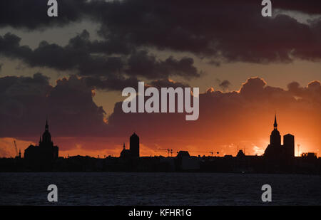 Il cielo colorato può essere visto in precedenza la silhouette della città durante il tramonto a Stralsund, Germania, 29 ottobre 2017. lo stesso giorno la tempesta davanti "herwart' interessato il traffico sulle strade, rotaie e sull'acqua nel Meclemburgo-Pomerania occidentale. photo: Stefan Sauer/dpa-zentralbild/dpa Foto Stock